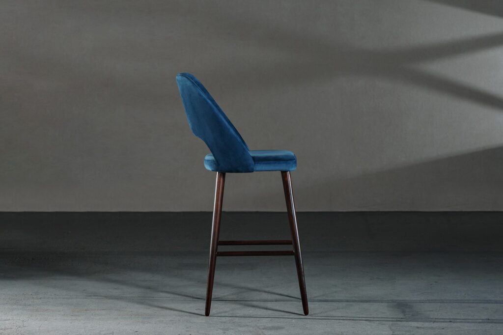 closeup blue chair with high legs room with gray walls Kriica Online Web Designer Freelance